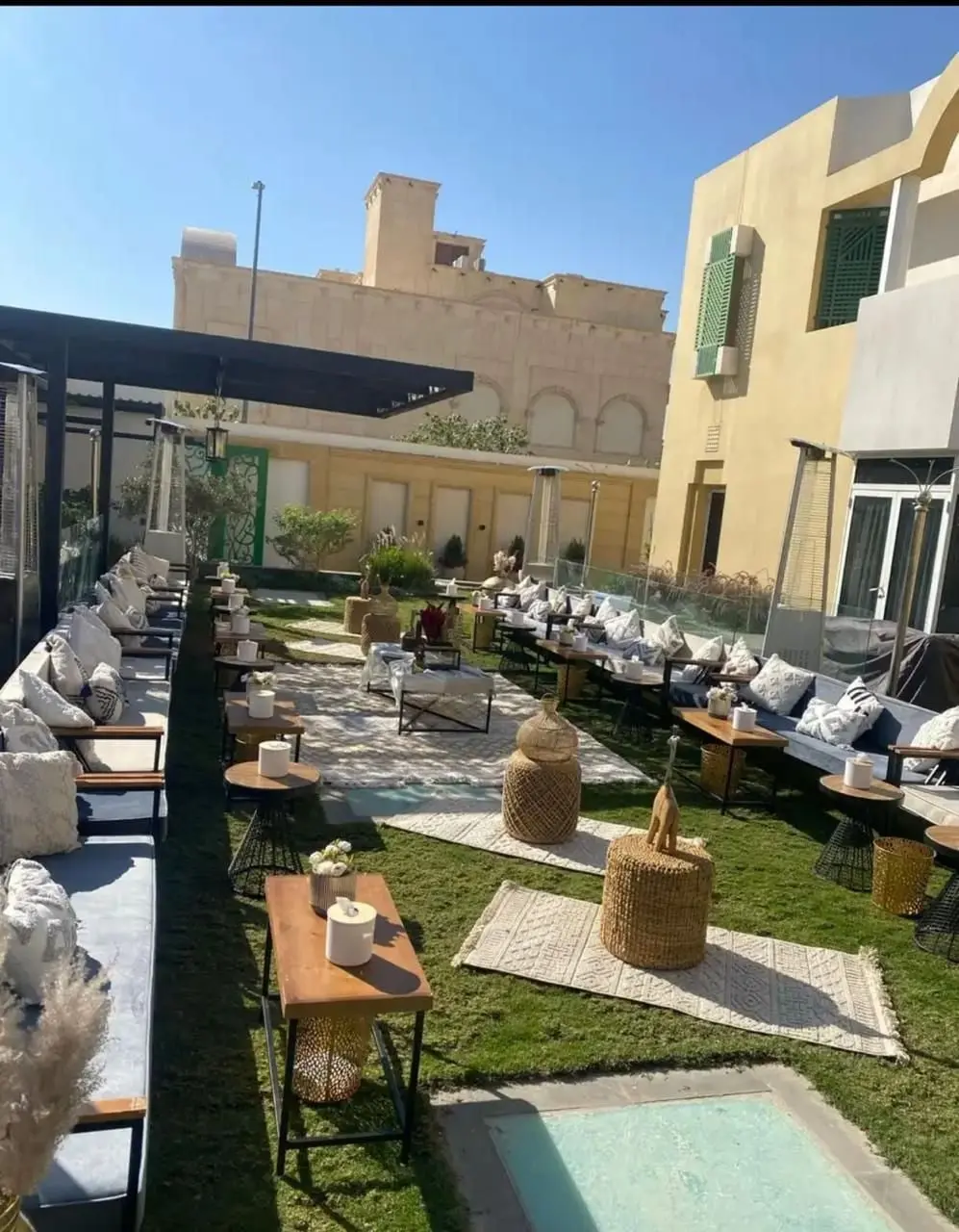 ممر جلسات خارجية بسجاد وطاولات خشبية