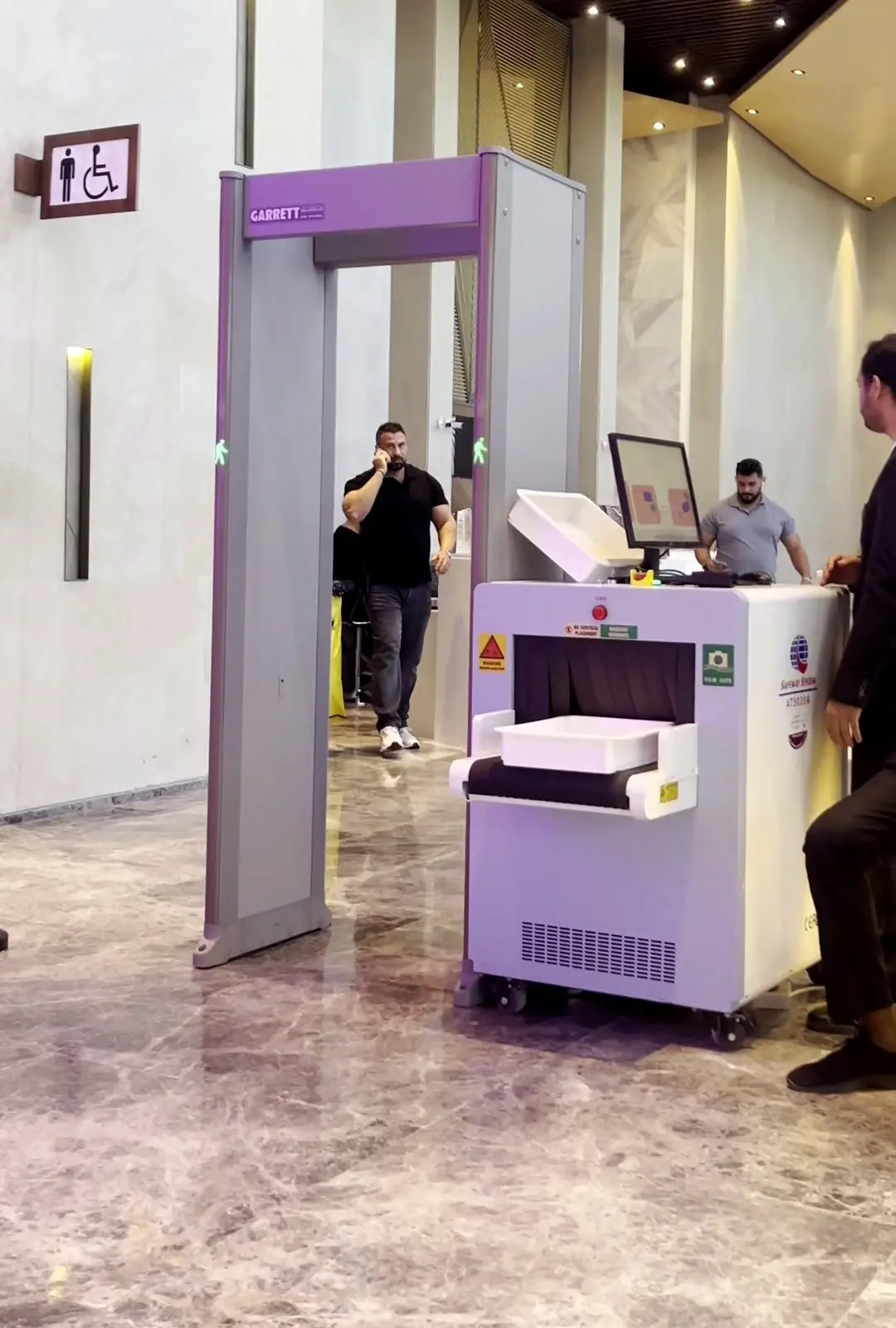 بوابة كشف معادن وجهاز فحص بالأشعة عند مدخل المعرض
